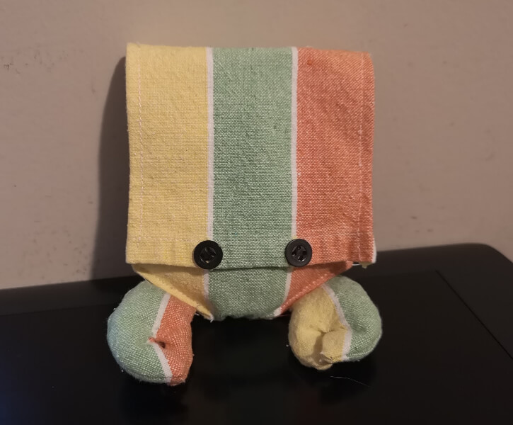 a small pouch with button eyes on the flap and two beanbag crab claws attached to the bottom